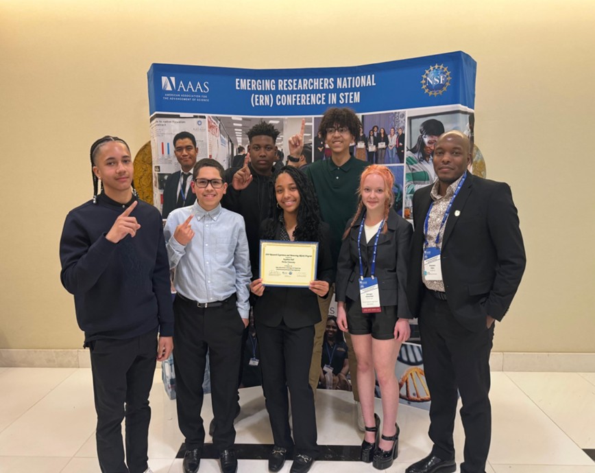 The six students in the Youth Engineers in the Sustainability of Electric Vehicles (YES-EV) program attend a conference with Brandon Allen (right), research assistant professor at Purdue University and ASPIRE Diversity and Culture of Inclusion (DCI) co-director. 