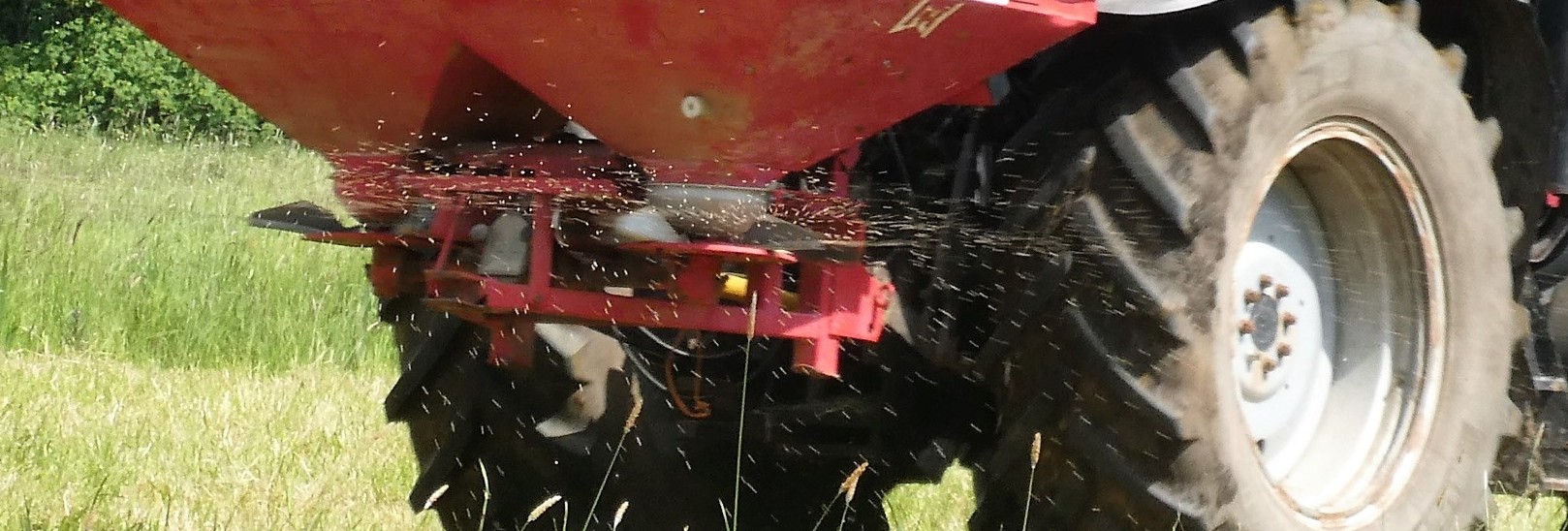 Tractor distributing fertilizer