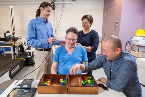 CNT students work with co-director Chet Moritz to deliver transcutaneous spinal cord stimulation to improve hand function for a participant with a spinal cord injury.